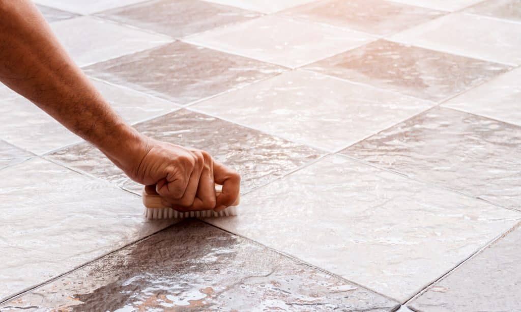 Men's hands are used to convert polishing cleaning on the tile floor.