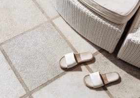 outdoor slippers near a sun lounger on a tile on a sunny day